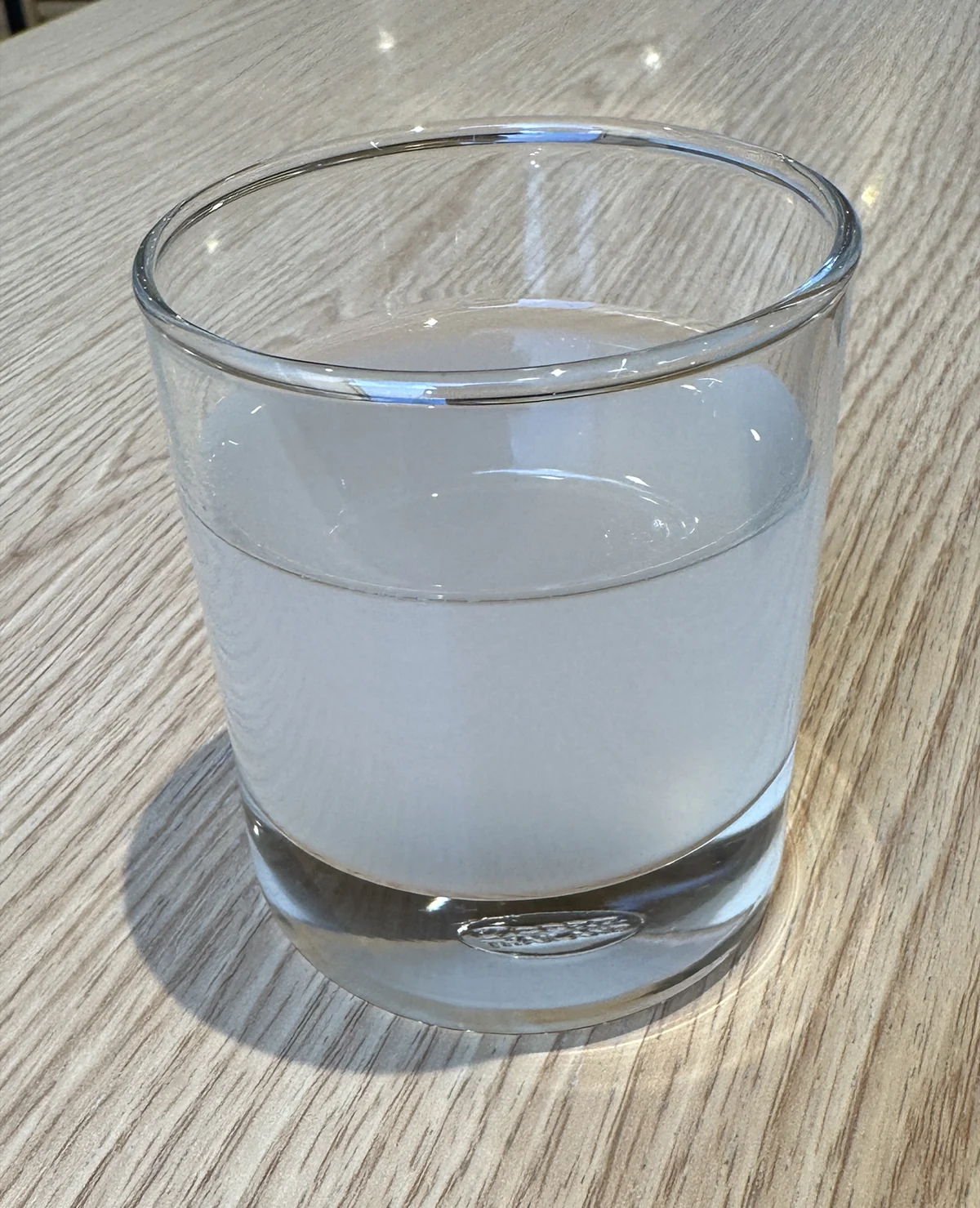 木目のテーブルに置かれた、ライチジュースの入ったグラス