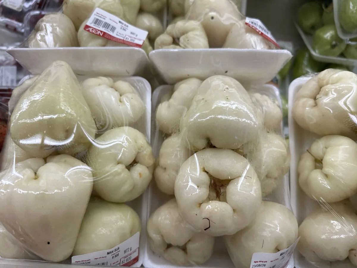 スーパーの陳列棚に並ぶ、白種のレンブ(パッケージ表示:MAN SUA)のパック詰め写真。ピンク種と同じ単価8,500ドン(100gあたり)で並んで売られている