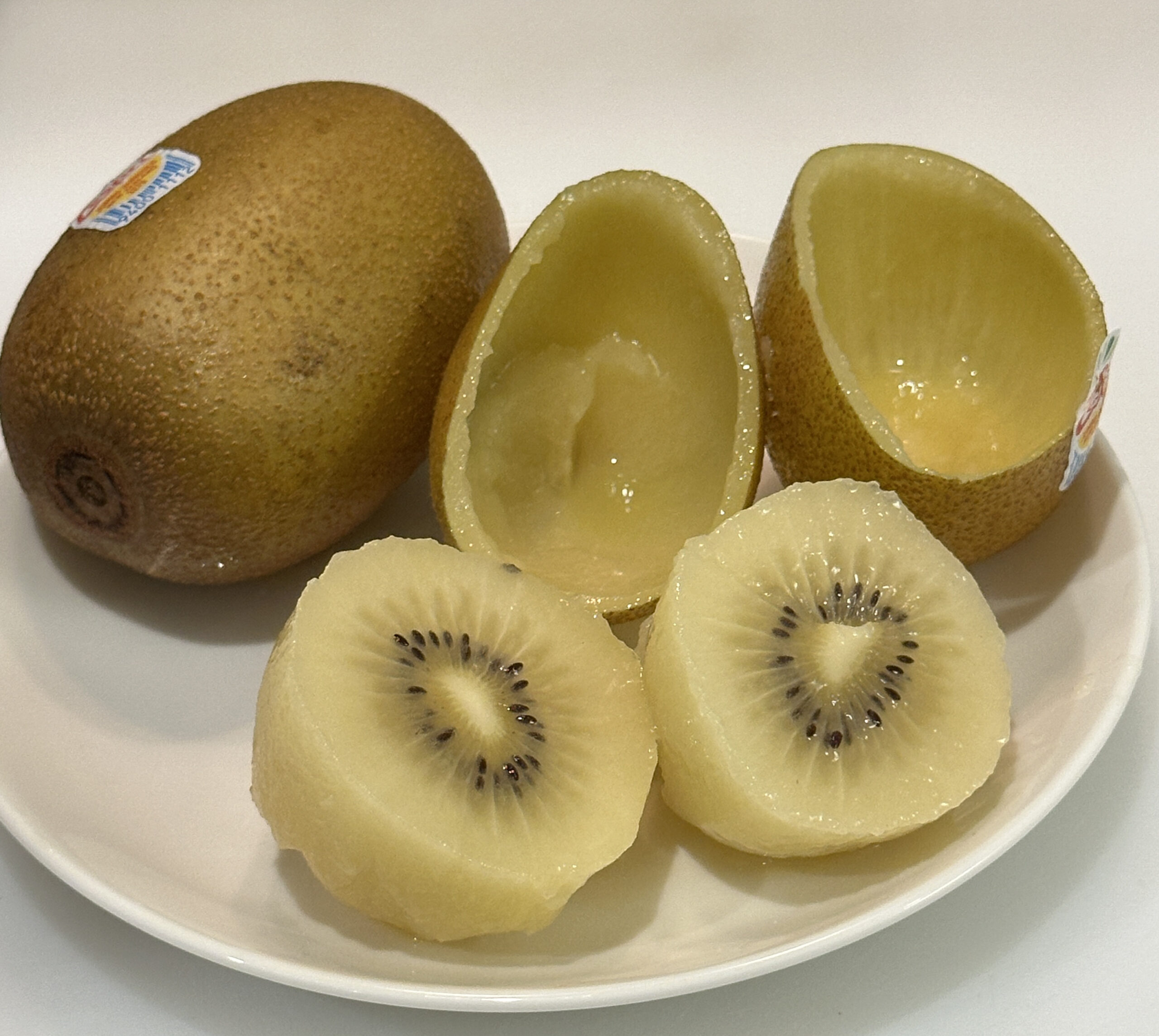Whole and cut SunGold kiwifruit after eating by the cut-and-scoop method