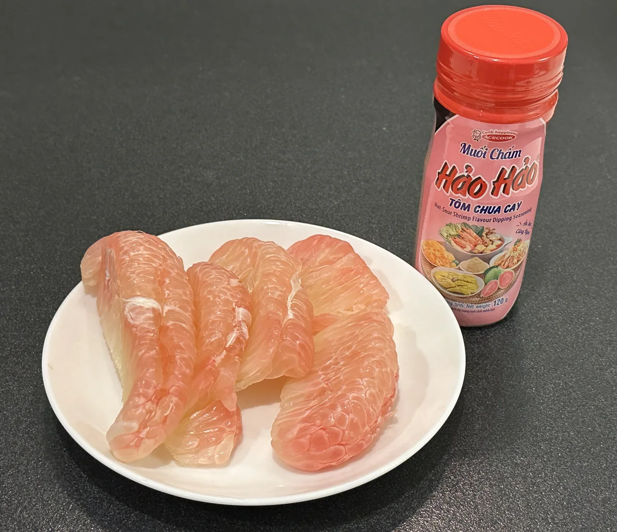 皿に盛ったピンク色のザボンの果肉とベトナムのつけ塩